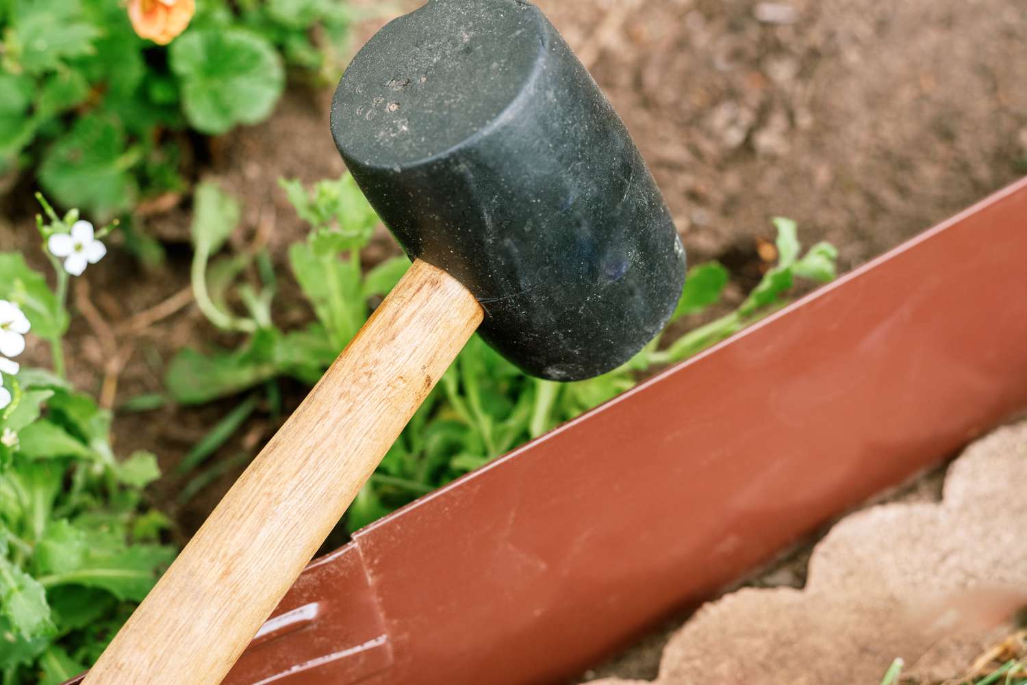 Utilisation d'un maillet en caoutchouc pour installer la bordure