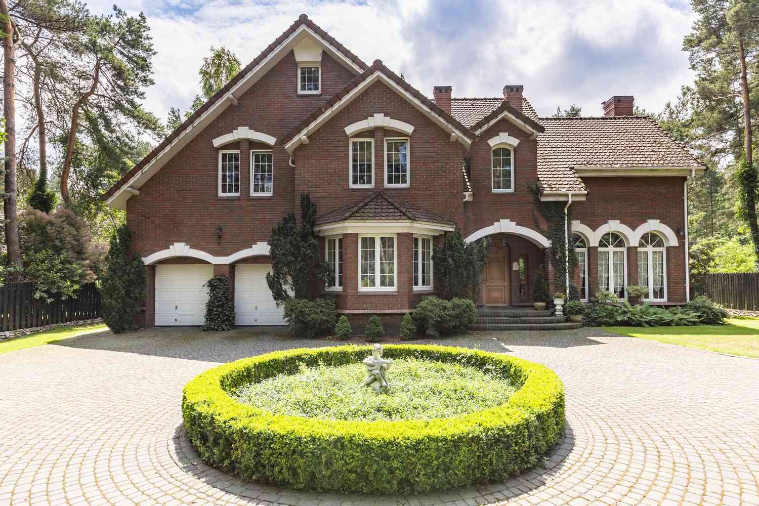 Allée en pavés arrondis devant une maison en briques