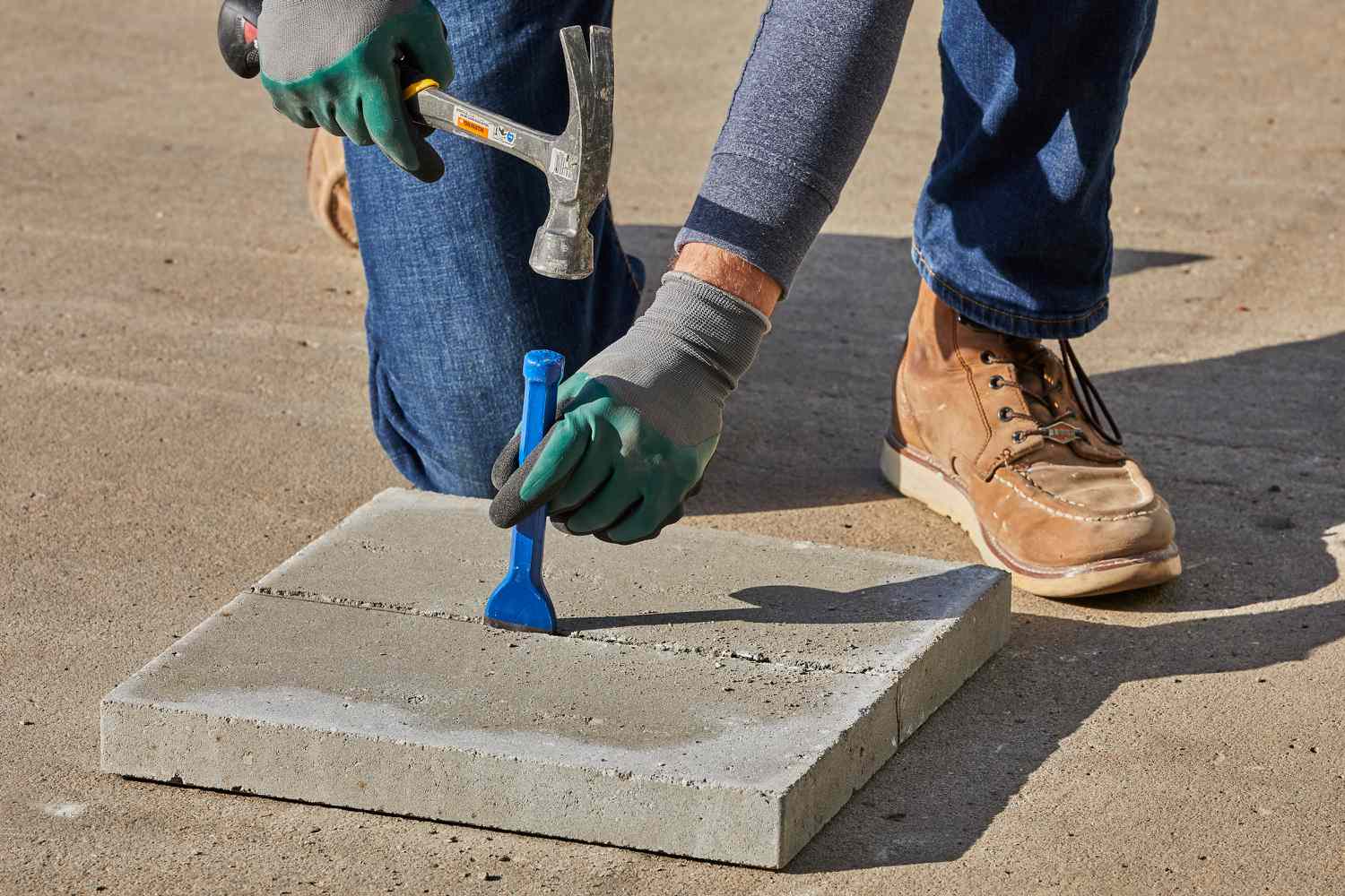 Utilisation d'un marteau et d'un ciseau pour casser le pavé