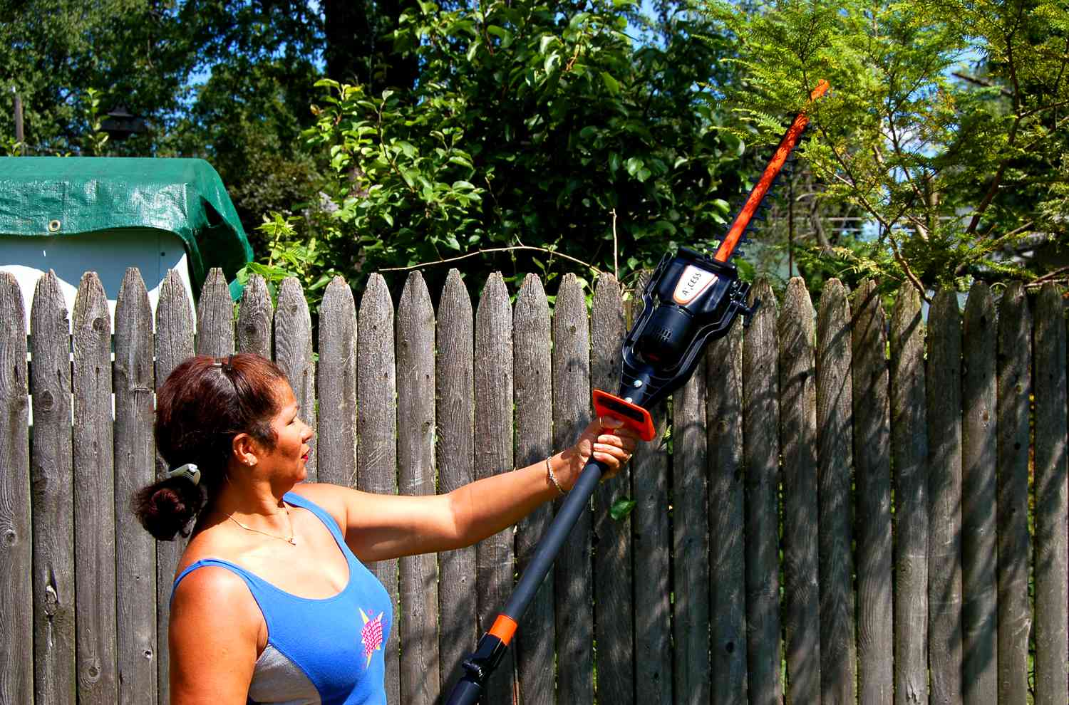 Femme taillant des branches d'arbre avec le coupe-bordure Remington Axcess