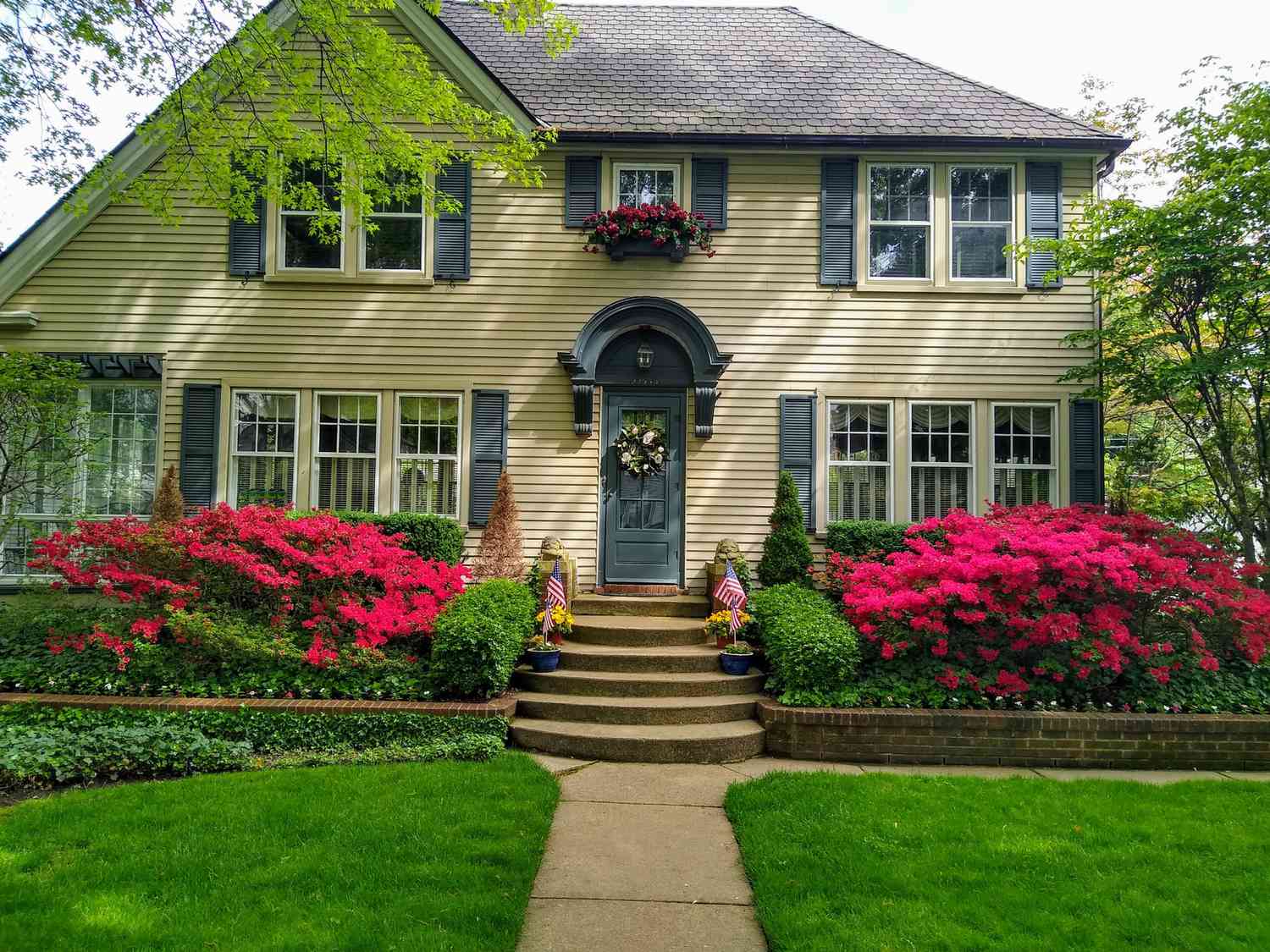 Parterre de fleurs surélevé devant une grande maison
