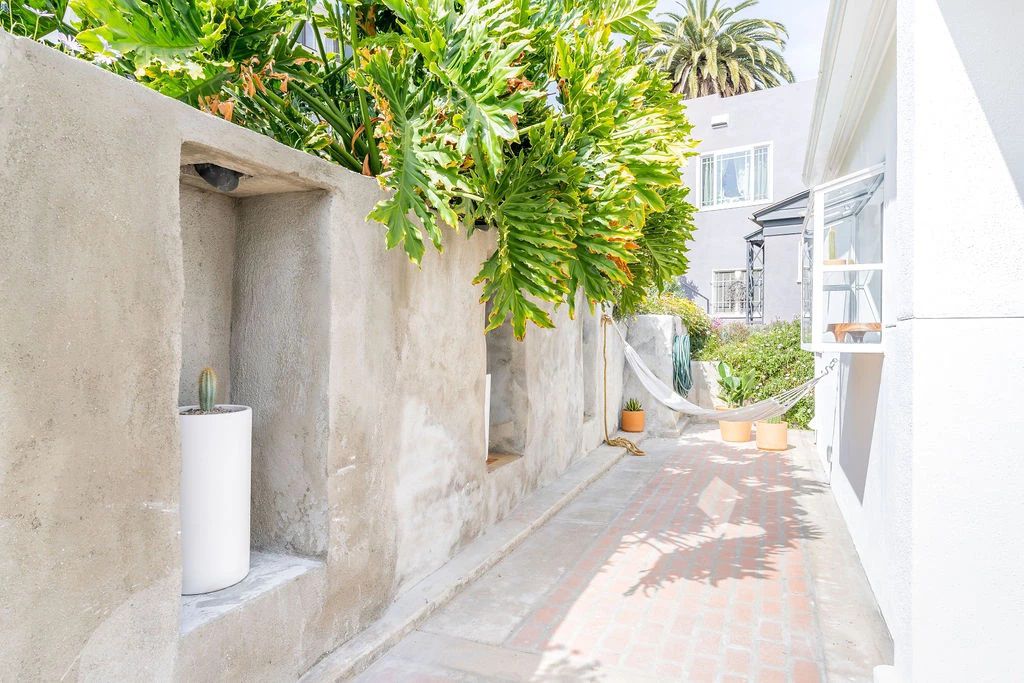 Un jardin étroit avec une allée en briques