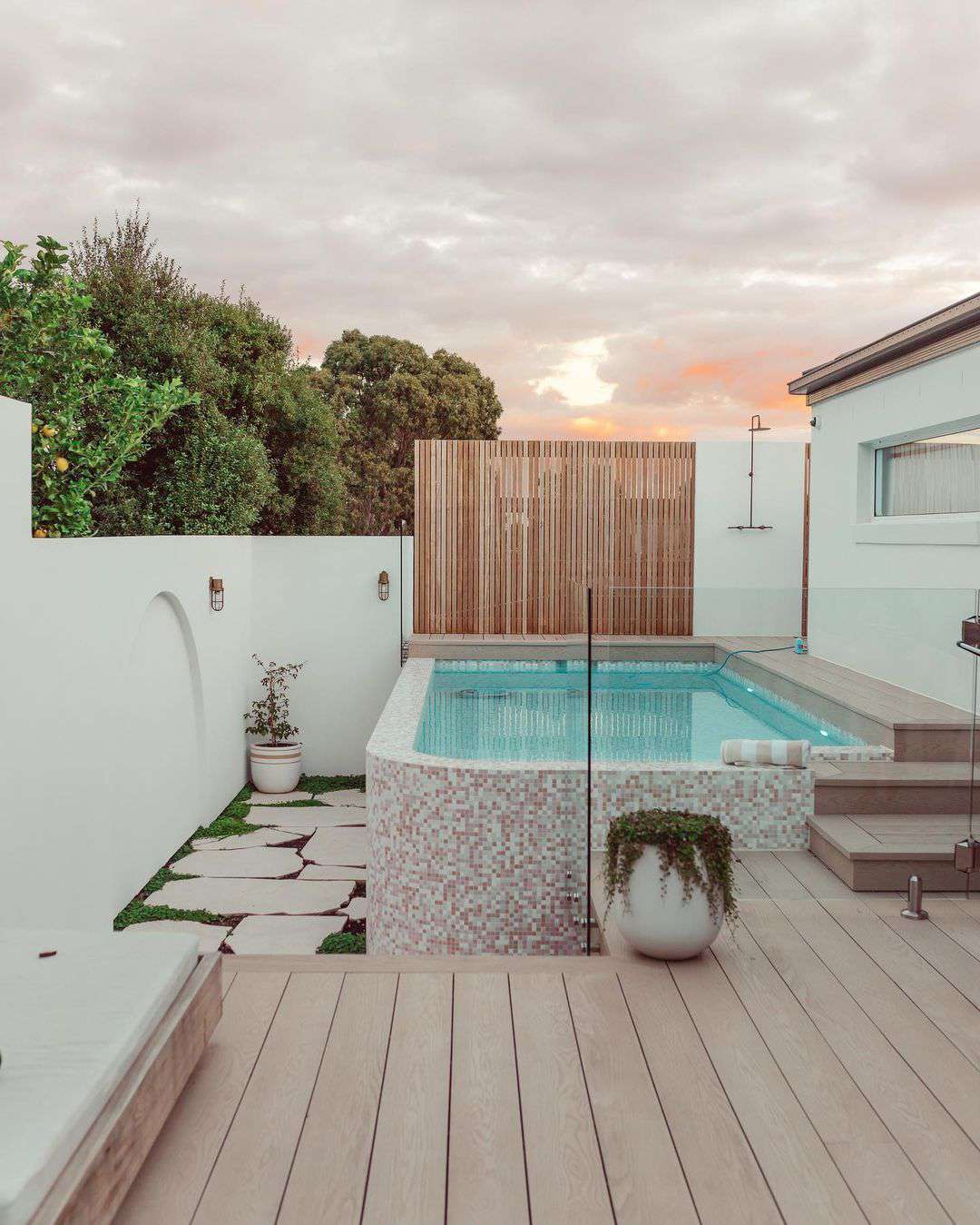 Une arrière-cour avec une allée menant à une piscine hors sol.