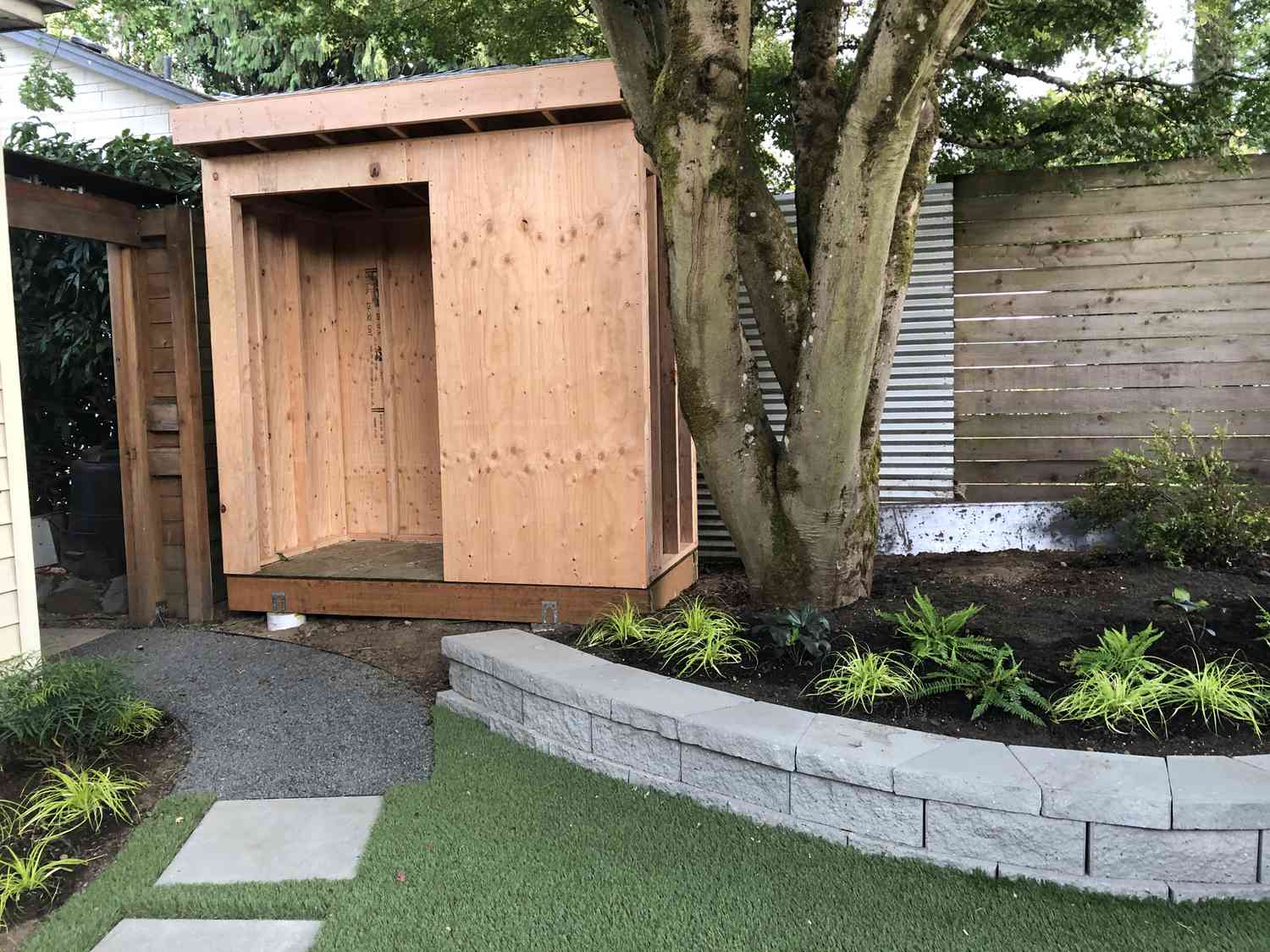 Une petite cour avec un sentier menant à un abri de jardin