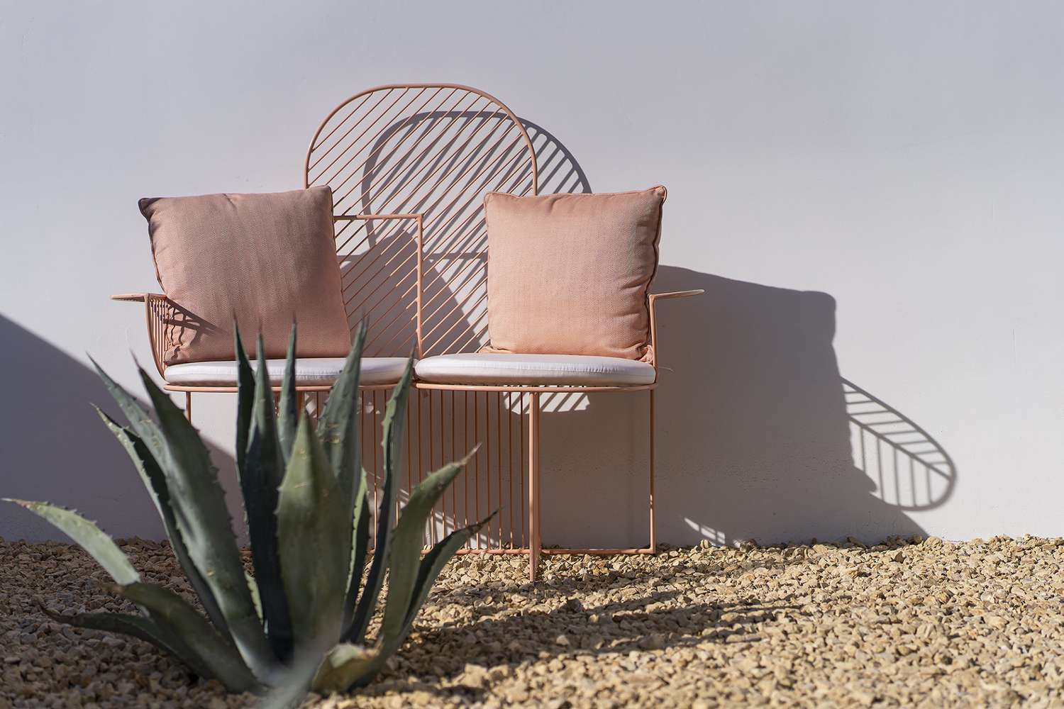 Un banc rose dans un coin salon de jardin