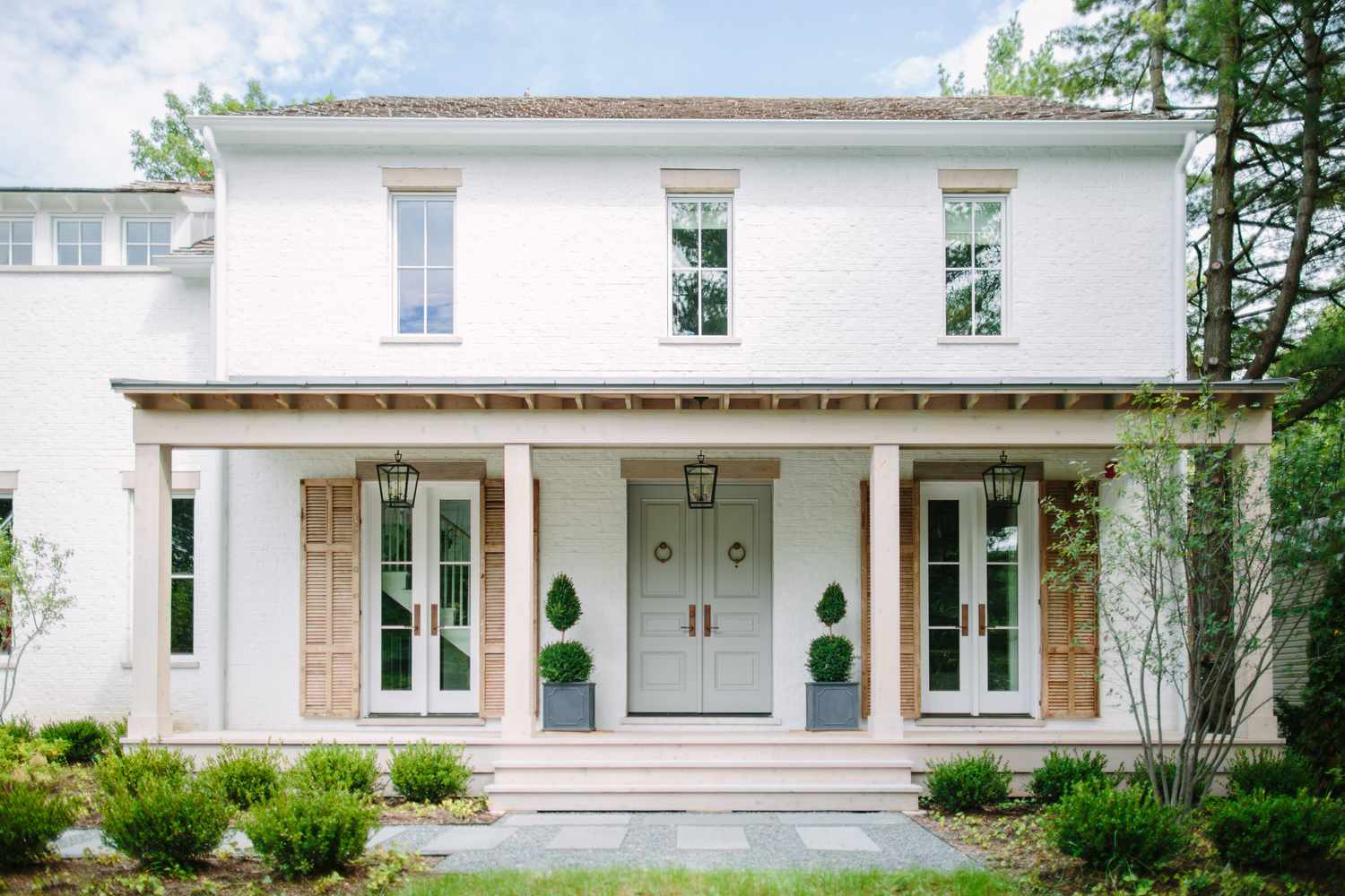 Une maison de style cottage avec un sentier en pierre et en béton