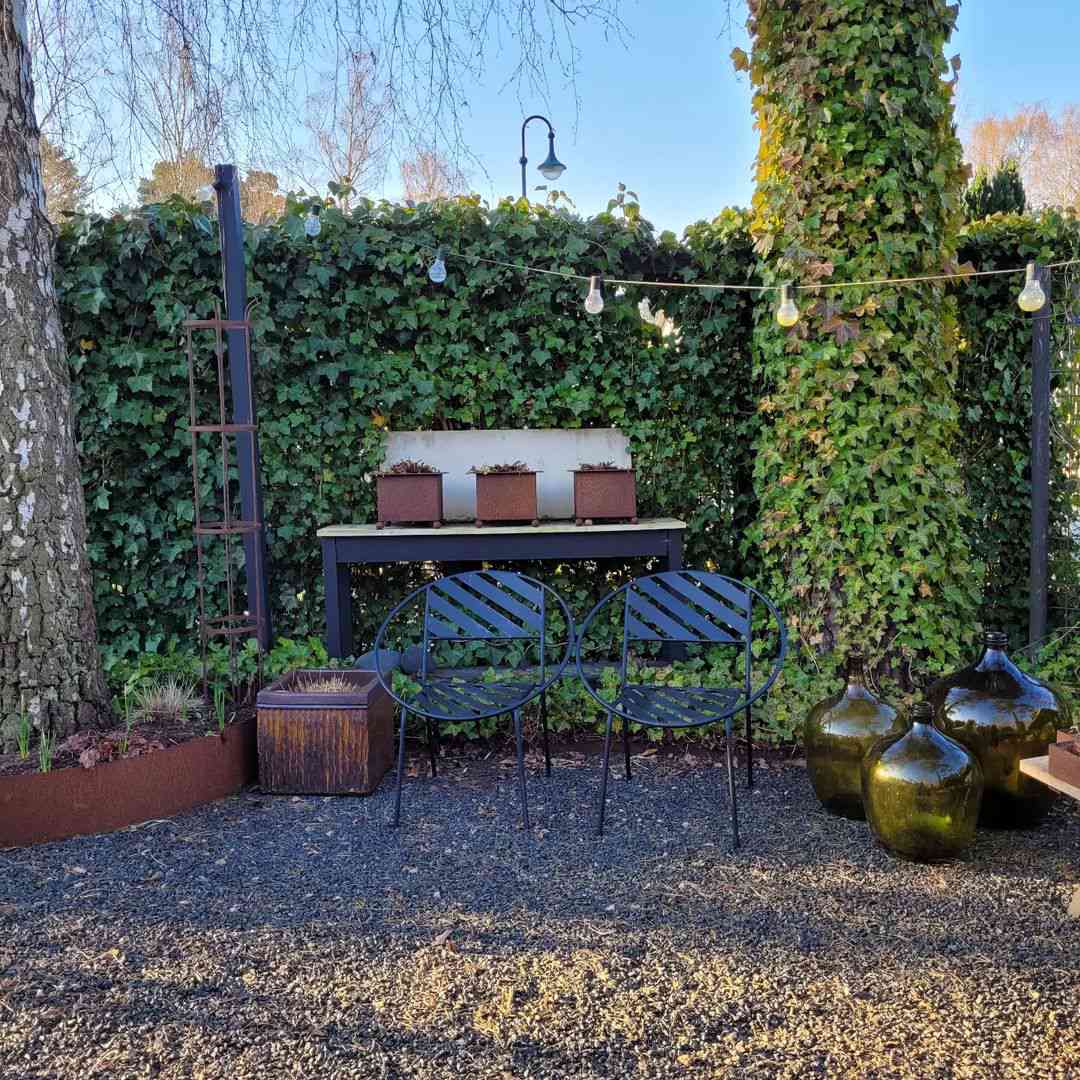 Terrasse en gravier avec mur recouvert de lierre