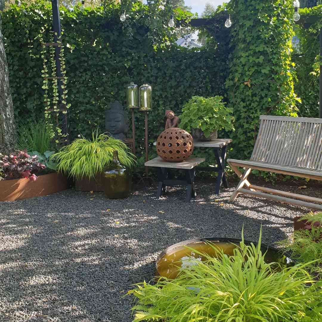 Jardin avec terrasse en gravier et banc