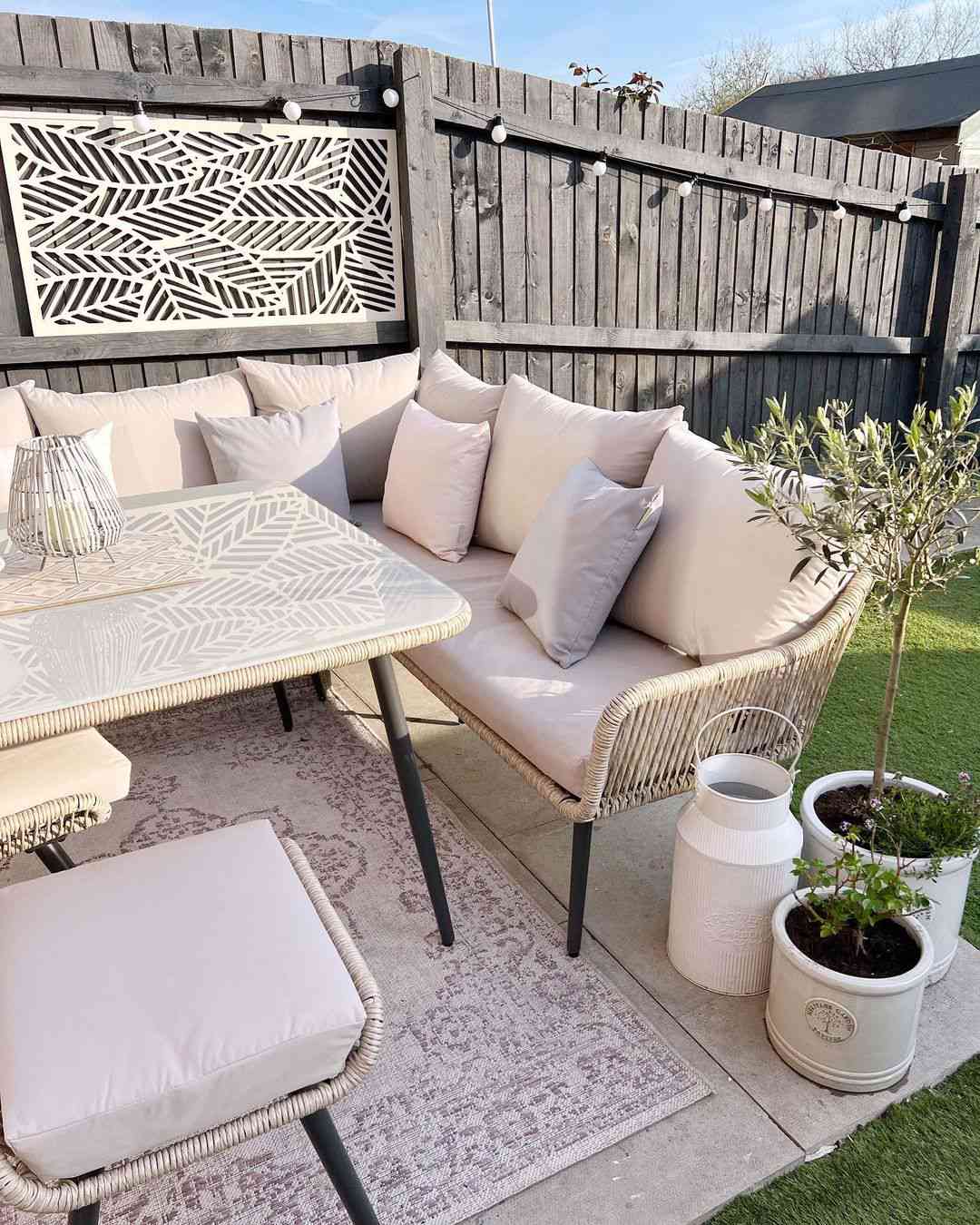 An outdoor sitting area with artwork on the fence