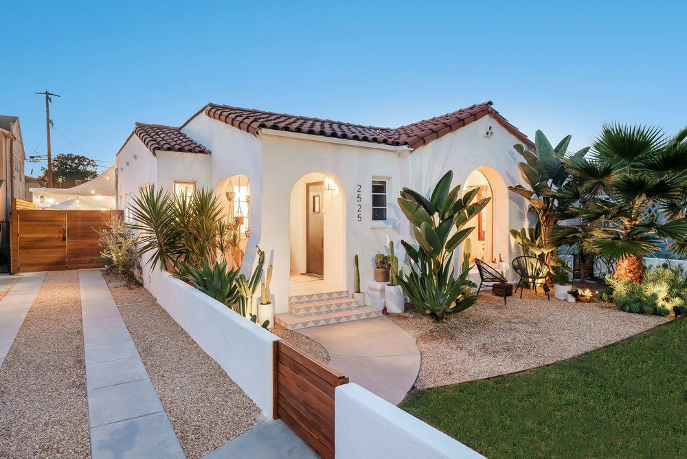 Une maison de style méditerranéen avec une rocaille à l'avant